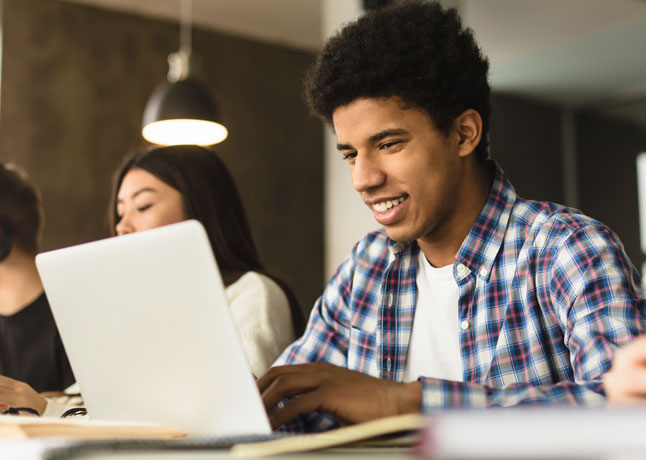 Teen typing on laptop