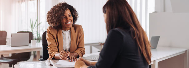 Two women discussing paperwork