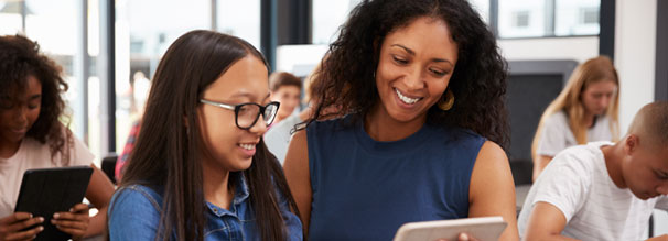 Woman looking at tablet with teen