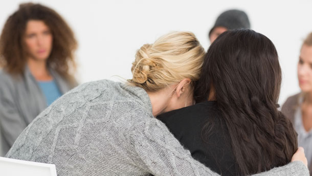 Women in support group comforting each other