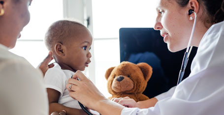 Doctor checking young child's heart rate